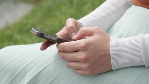 Female holds smartphone while texting 4K close-up video