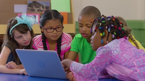 Group of students use laptop computer in school classroom