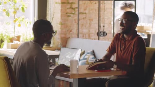 Afro-American Male Coworkers Meeting and Talking in Cafe