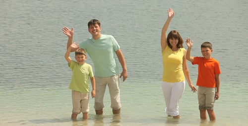 Happy Family Wading at the Beach on Sunny Day