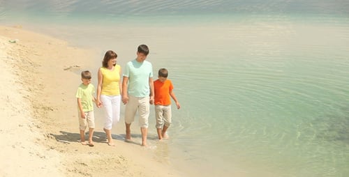 Happy Family Walking on Sandy Beach Shoreline