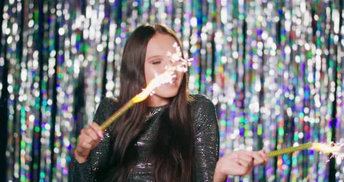 Woman Smiling Holding Sparklers at Birthday Celebration