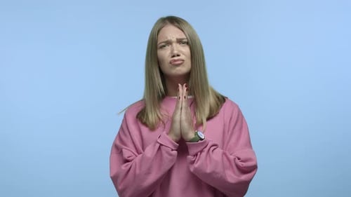 Young Woman Pleading With Hands Together