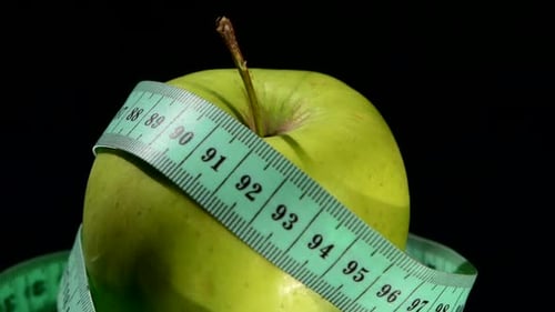 Green, Fresh Apple with Measuring Tape on Black, Rotation, Reflection, Close Up