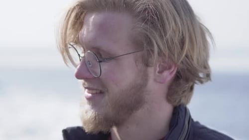 Young Man Smiling at the Camera, Beach Background
