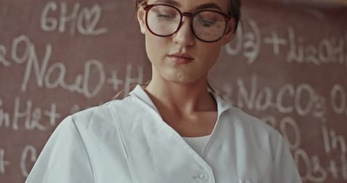 Young Woman Scientist Mixing Chemicals in Test Tubes
