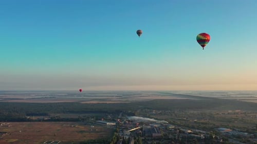 Beautiful balloons fly over the forest, park, city. Beautiful evening balloon flight.