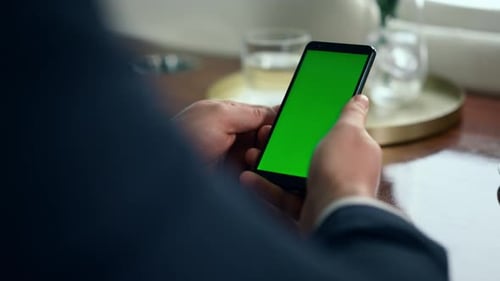 Manos de cerca sosteniendo el teléfono inteligente con pantalla de clave croma