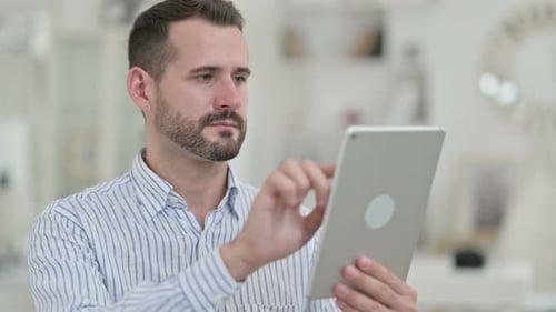 Adult Man Using Tablet in Office Setting