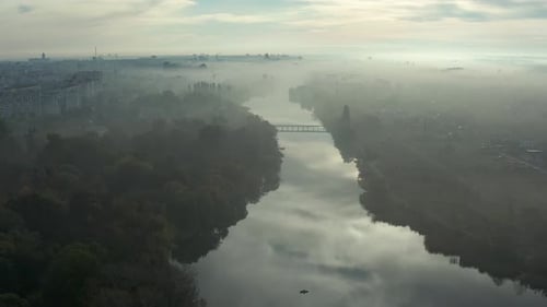 Beautiful morning, summer flight over the river. The bridge over the river in the fog, at dawn.