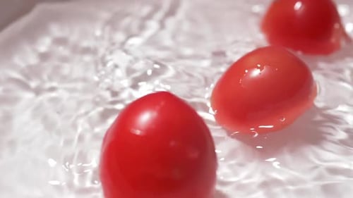 Tomatoes Splashing into Water Being Cleaned