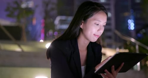 Woman Using Tablet at Night in City