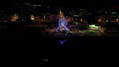 Luftaufnahme eines kleinen Vergnügungsparks mit nächtlichen Lichtern in Griechenland.