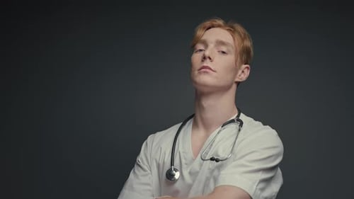Doctor With Stethoscope Standing in Front of Gray Background