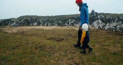 Young Adult Woman Walk with Daughter on Ocean Edge Aside the Cliff