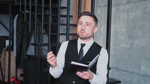Man in Vest Taking Notes in Urban Office
