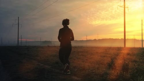 Woman Runs on Path at Sunrise in the Country