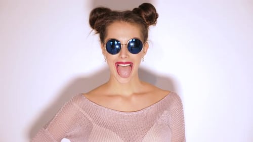 Young Woman Sticks Tongue Out Wearing Sunglasses
