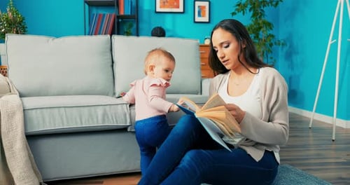 Woman Reading Book With Blonde Haired Baby