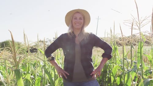 Video of happy caucasian woman standing in field on sunny day