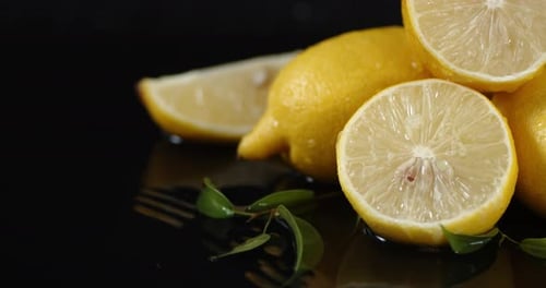 Fresh Yellow Lemons and Leaves on Black