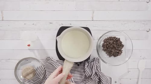 Zeitraffer. Flache Lage. Zubereitung hausgemachter Schokoladenganache für Schokoladen-Himbeer-Cupcakes.
