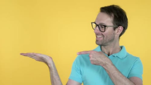 Man Showing Product on Side Yellow Background
