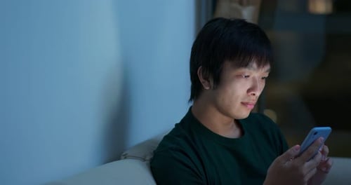 Man Use of Mobile Phone at Home in The Evening