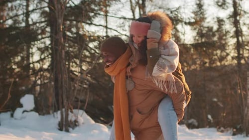 Woman Riding On Man Shoulders In Winter