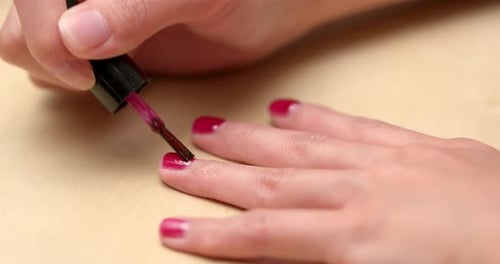 Apply red nail polish on finger nail at home