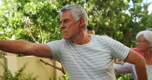 Adults Exercise Together Outdoors in Suburban Garden