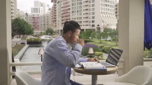 Young businessman taking notes in cafe.
