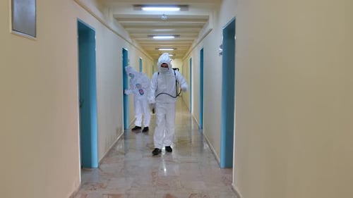 Figures in Hazmat Suits Disinfecting Interior