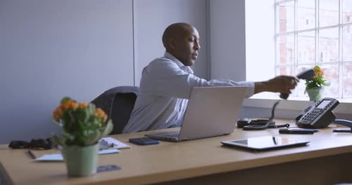 Businessman working in office, talking on the phone