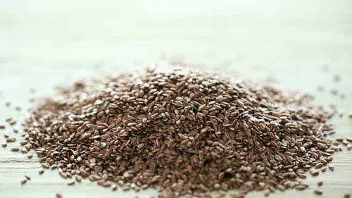 Pile of Flax Seeds on Wooden Surface