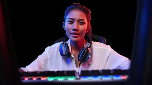 Woman in front of Keyboard wearing Headphones talking