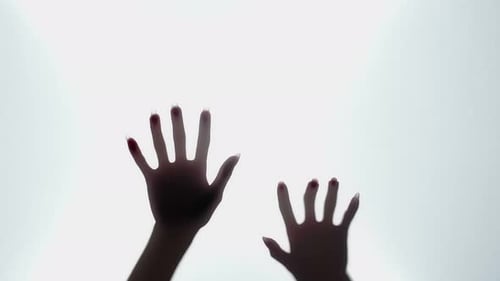 Abstract Silhouette of Hands Moving Behind Light