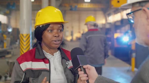 Une ingénieure donne une interview sur l'usine à un journaliste de télévision