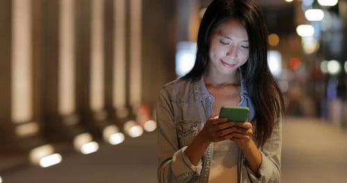 Woman using mobile phone at night
