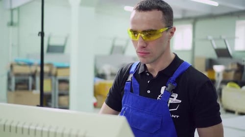 Um operário masculino está parado no monitor