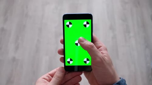 Male Using Smartphone with Green Screen in Home
