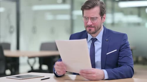 Worried Businessman Reading Bad News in Office