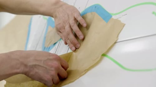 Des mains d'hommes préparent un hélicoptère ou un avion blanc pour la peinture