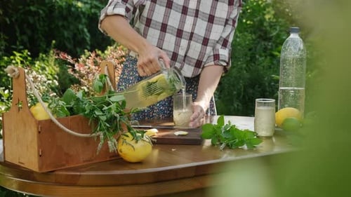 Woman Pours Homemade Lemonade on a Summer Day