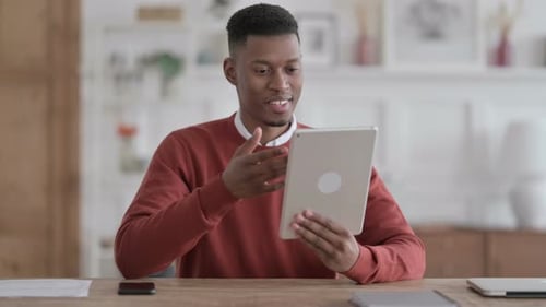 African Man making Video Call on Tablet in Office