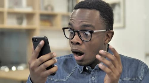 Man Surprised While Using Smartphone