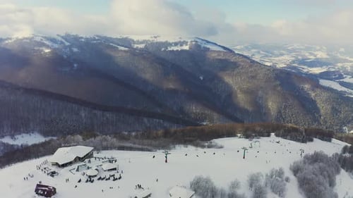 Old Ski Station on a Snowy Mountain Slope with a Lot of People on Skis and Snowboards