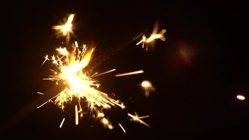 Gold Sparkler Burning in Dark Night Background