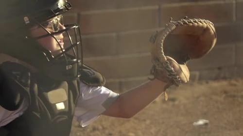 Un niño juega al receptor en un partido de béisbol de las ligas menores.