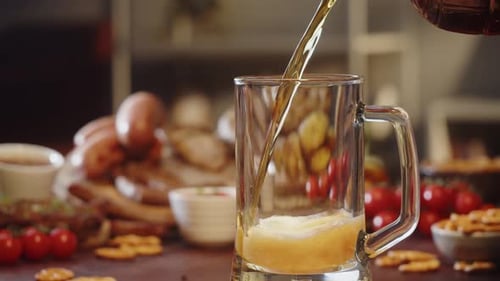 Beer Pouring into Glass Mug with Sausages